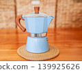 Blue moka pot coffee maker on a wooden table 139925626