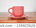 Pink ceramic coffee cup on a saucer against a white background 139925628