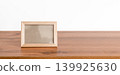 Empty small wooden picture frame on a wooden table surface 139925630