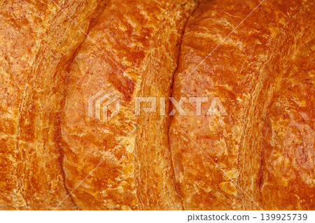 Detailed texture of fresh French croissant. Macro of golden brown baked dough isolated on white Detailed texture of fresh French croissant. Macro of golden brown baked dough isolated on white 139925739