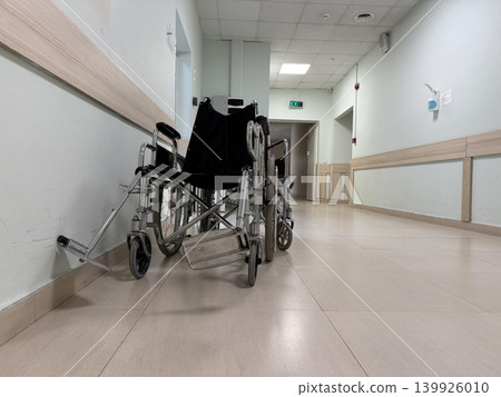 Empty wheelchairs placed along the corridor of a hospital waiting for patients and caregivers Empty wheelchairs placed along the corridor of a hospital waiting for patients and caregivers 139926010
