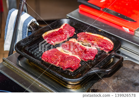 Raw Seasoned Beef Steaks Just Placed on Cast Iron Grill Pan at Start of Cooking Process Raw Seasoned Beef Steaks Just Placed on Cast Iron Grill Pan at Start of Cooking Process 139926578