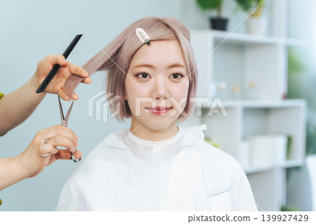 一位淺色頭髮的女士正在理髮。 一位淺色頭髮的女士正在理髮。 139927429