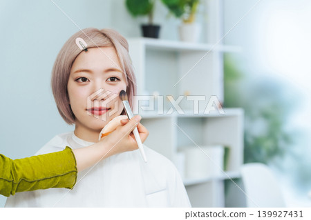 一位淺色頭髮的女士正在化妝。 一位淺色頭髮的女士正在化妝。 139927431