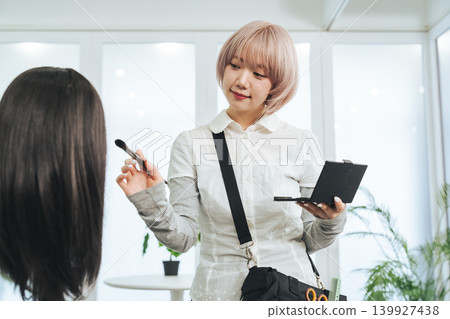 Female staff with light-colored hair doing makeup Female staff with light-colored hair doing makeup 139927438