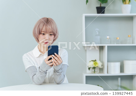 一位淺色頭髮的女子正在使用智慧型手機 一位淺色頭髮的女子正在使用智慧型手機 139927445