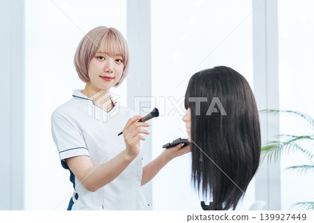 Female staff practicing makeup on a mannequin Female staff practicing makeup on a mannequin 139927449