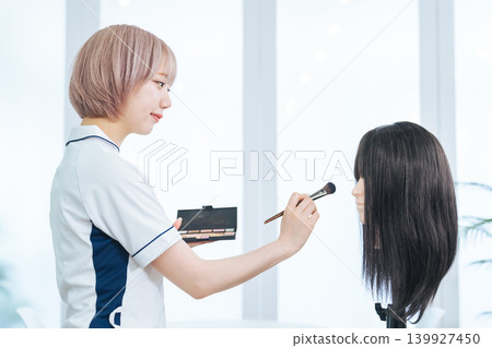 Female staff with light-colored hair doing makeup Female staff with light-colored hair doing makeup 139927450