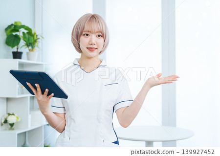 一位淺色頭髮的女工作人員手持平板電腦為你提供指導。 139927452