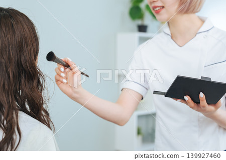 Female staff with light-colored hair doing makeup Female staff with light-colored hair doing makeup 139927460