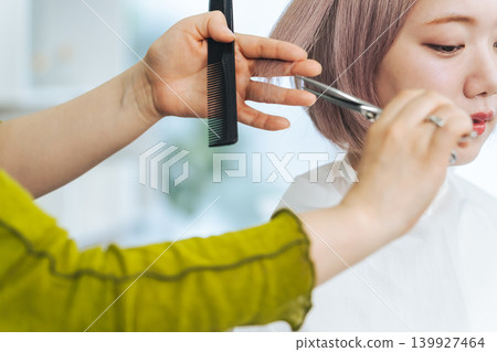 一位淺色頭髮的女士正在理髮。 一位淺色頭髮的女士正在理髮。 139927464