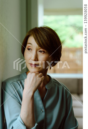Woman looking out the window Woman looking out the window 139928058