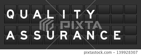 Black color analog flip board with word quality assurance on gray background 139928307