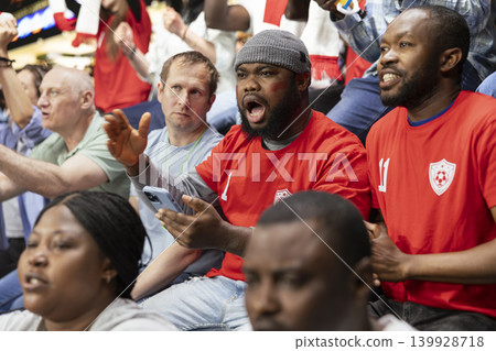 Diverse soccer fans following in-play live odds on phone betting app, cheering and watching exciting football match from stadium stands. Supporters use mobile sportsbook for risky wager, online bet. Diverse soccer fans following in-play live odds on phone betting app, cheering and watching exciting football match from stadium stands. Supporters use mobile sportsbook for risky wager, online bet. 139928718