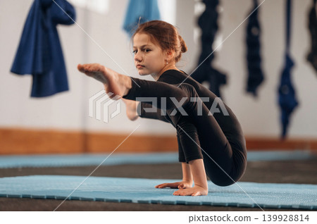 Concentration and strength conception, on the hands. Child practicing yoga on a mat in a fitness studio Concentration and strength conception, on the hands. Child practicing yoga on a mat in a fitness studio 139928814