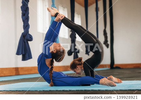 Two children practicing yoga together in a fitness studio Two children practicing yoga together in a fitness studio 139928921