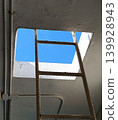 Rusted ladder reaching toward a frame of endless blue 139928943
