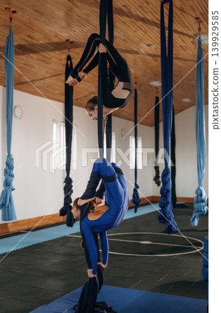 Two children practicing yoga together in a fitness studio 139929585