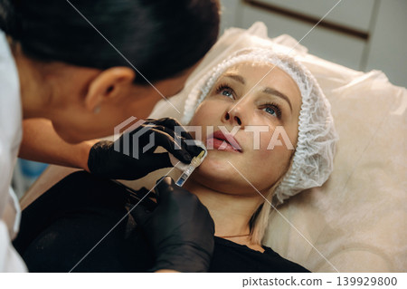 Cosmetologist performing a facial injection procedure in a beauty clinic Cosmetologist performing a facial injection procedure in a beauty clinic 139929800