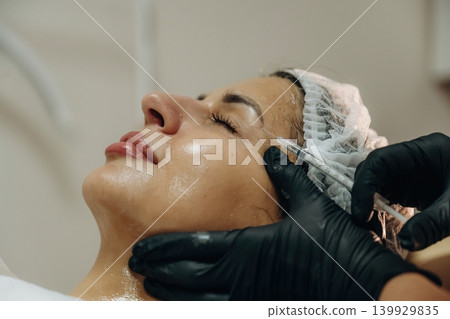 Cosmetologist performing a facial injection procedure in a beauty clinic Cosmetologist performing a facial injection procedure in a beauty clinic 139929835