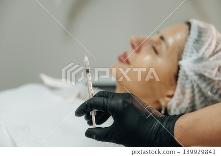 Cosmetologist performing a facial injection procedure in a beauty clinic Cosmetologist performing a facial injection procedure in a beauty clinic 139929841