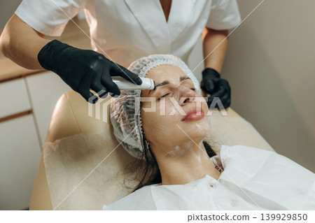 Professional skincare. Close-up of a facial treatment with a cosmetic device in a beauty clinic Professional skincare. Close-up of a facial treatment with a cosmetic device in a beauty clinic 139929850