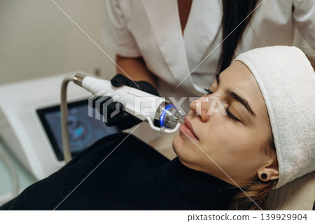 Getting ready. Close-up of a facial skincare treatment with a cosmetic device in a beauty clinic Getting ready. Close-up of a facial skincare treatment with a cosmetic device in a beauty clinic 139929904