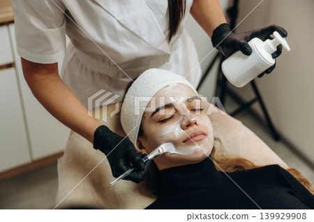 Applying the cream. Close-up of a facial skincare treatment with a cosmetic device in a beauty clinic Applying the cream. Close-up of a facial skincare treatment with a cosmetic device in a beauty clinic 139929908