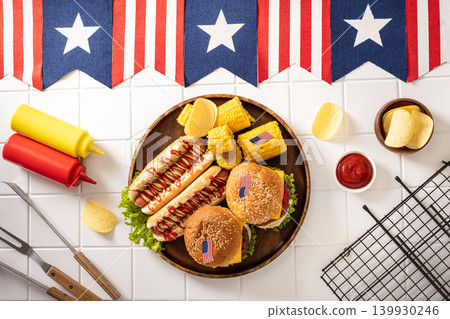 Fourth of July barbecue plate with burgers hot dogs and patriotic decorations Fourth of July barbecue plate with burgers hot dogs and patriotic decorations 139930246