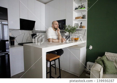 Happy Man Holding Ereader And Reading Ebook at Home Happy Man Holding Ereader And Reading Ebook at Home 139930287