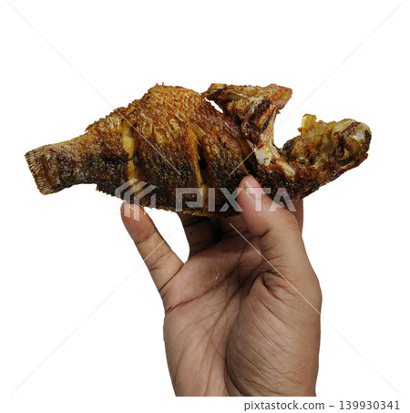 Close up of crispy fried fish held in hand isolated on white. Close up of crispy fried fish held in hand isolated on white. 139930341