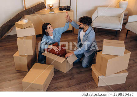 High five hands gesture, successful. Playful couple enjoying time together while moving into a new home High five hands gesture, successful. Playful couple enjoying time together while moving into a new home 139930485