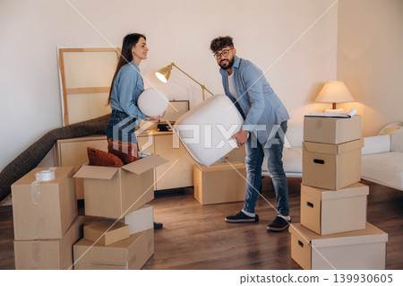 Couple packing cardboard boxes while preparing to move into a new home Couple packing cardboard boxes while preparing to move into a new home 139930605