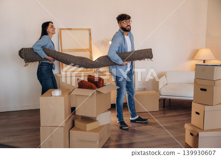 Happy couple organizing belongings and packing boxes during a home relocation Happy couple organizing belongings and packing boxes during a home relocation 139930607