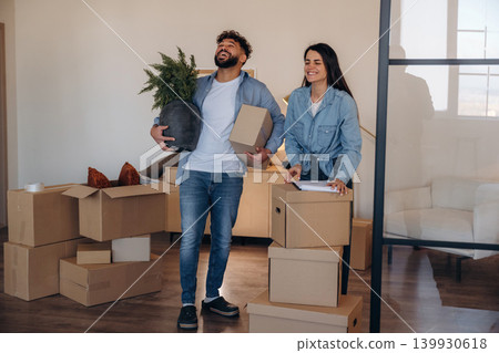 Couple reviewing documents and planning their new home after moving Couple reviewing documents and planning their new home after moving 139930618