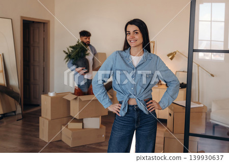 Waiting for the man to place the object. Positive couple placing a potted plant in their new apartment during the moving process Waiting for the man to place the object. Positive couple placing a potted plant in their new apartment during the moving process 139930637