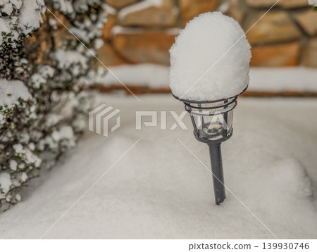 Outdoor Garden Light Covered in Fresh Snow with Warm Glow During Winter Evening Scene Outdoor Garden Light Covered in Fresh Snow with Warm Glow During Winter Evening Scene 139930746