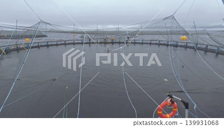 Large fish farm in the water with nets under cloudy sky as background 139931068