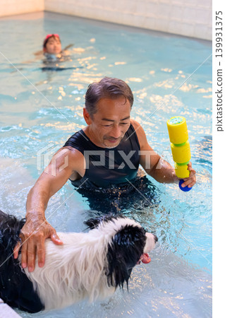 一名男子在游泳池裡和他的狗玩耍 139931375