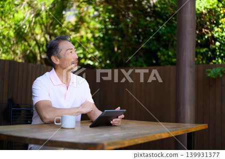 A man using a tablet outdoors A man using a tablet outdoors 139931377