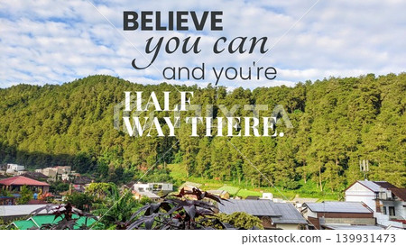 A motivational quote in bold and script text overlaid on a scenic view of a forested mountain and buildings below. The quote reads, "Believe you can and you're halfway there." A motivational quote in bold and script text overlaid on a scenic view of a forested mountain and buildings below. The quote reads, "Believe you can and you're halfway there." 139931473
