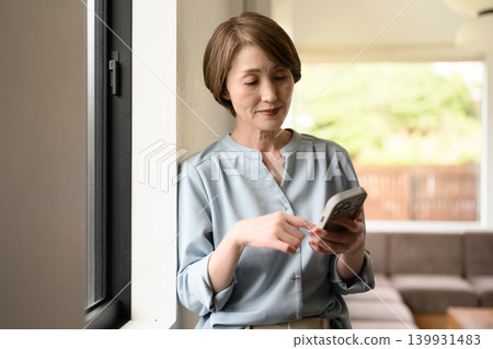 一個在窗邊操縱智能手機的女人 139931483