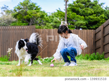 A girl and her dog playing in the yard A girl and her dog playing in the yard 139931510
