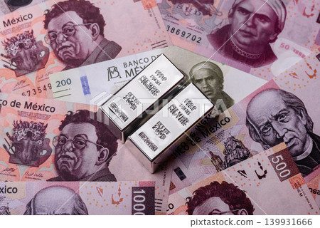 A silver bar, white metal against a backdrop of Mexican money, concept for the sales market A silver bar, white metal against a backdrop of Mexican money, concept for the sales market 139931666