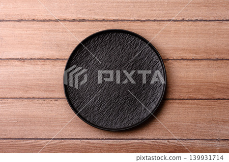 An empty ceramic round plate, kitchen utensils for a dinner table. An empty plate An empty ceramic round plate, kitchen utensils for a dinner table. An empty plate 139931714