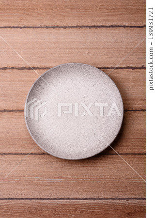 An empty ceramic round plate, kitchen utensils for a dinner table. An empty plate An empty ceramic round plate, kitchen utensils for a dinner table. An empty plate 139931721