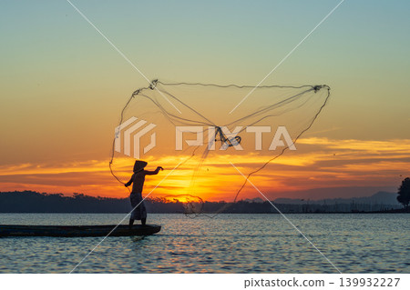 Traditional Fisherman Working on Wooden Boat at Sunset Traditional Fisherman Working on Wooden Boat at Sunset 139932227