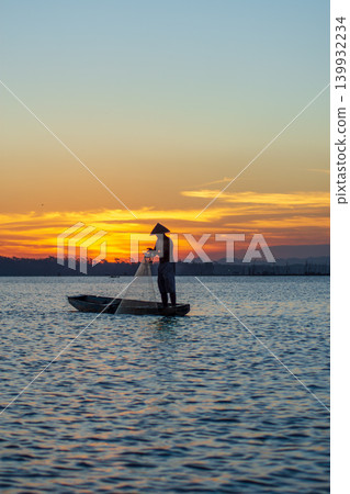 Traditional Fisherman Working on Wooden Boat at Sunset Traditional Fisherman Working on Wooden Boat at Sunset 139932234