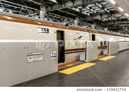 A scene from a station platform featuring a parked Shinkansen train and platform screen doors [Tsuruga Station, Hokuriku Shinkansen] 139932759