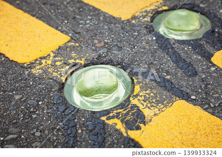 Paired Green Road Studs In Worn Asphalt Paired Green Road Studs In Worn Asphalt 139933324